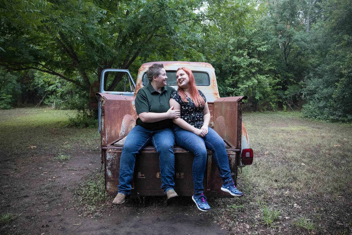 couple sitting on the tailgate of a pickup truck