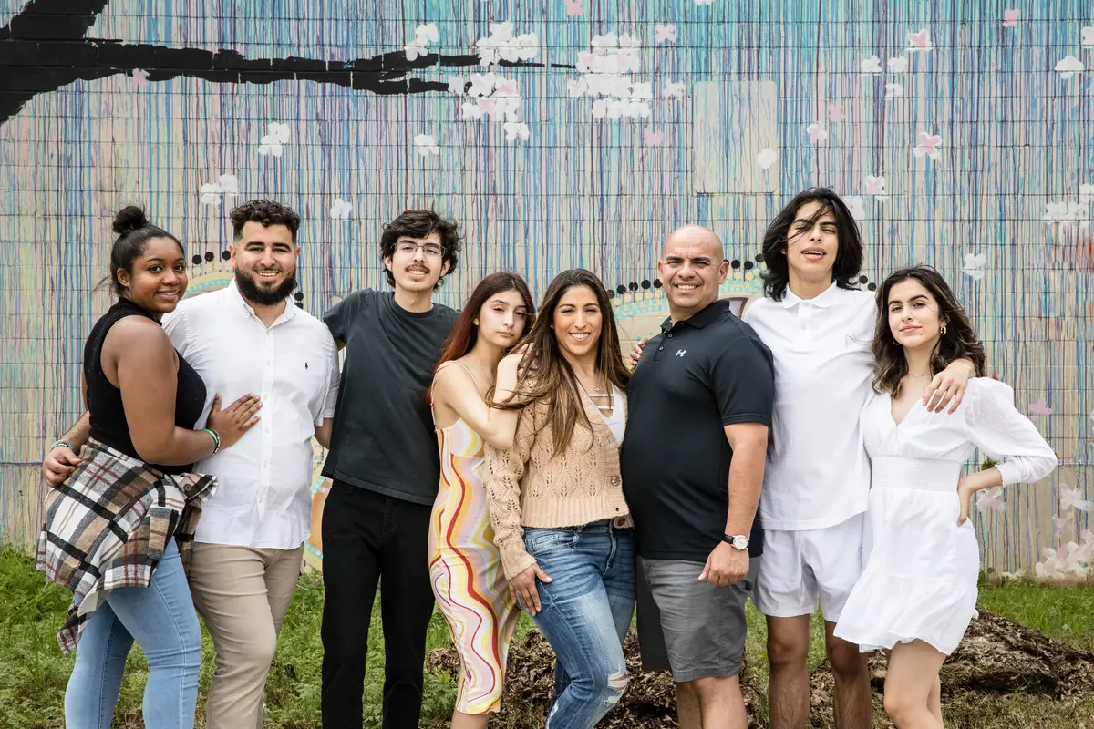 family of eight in front of a painted mural wall