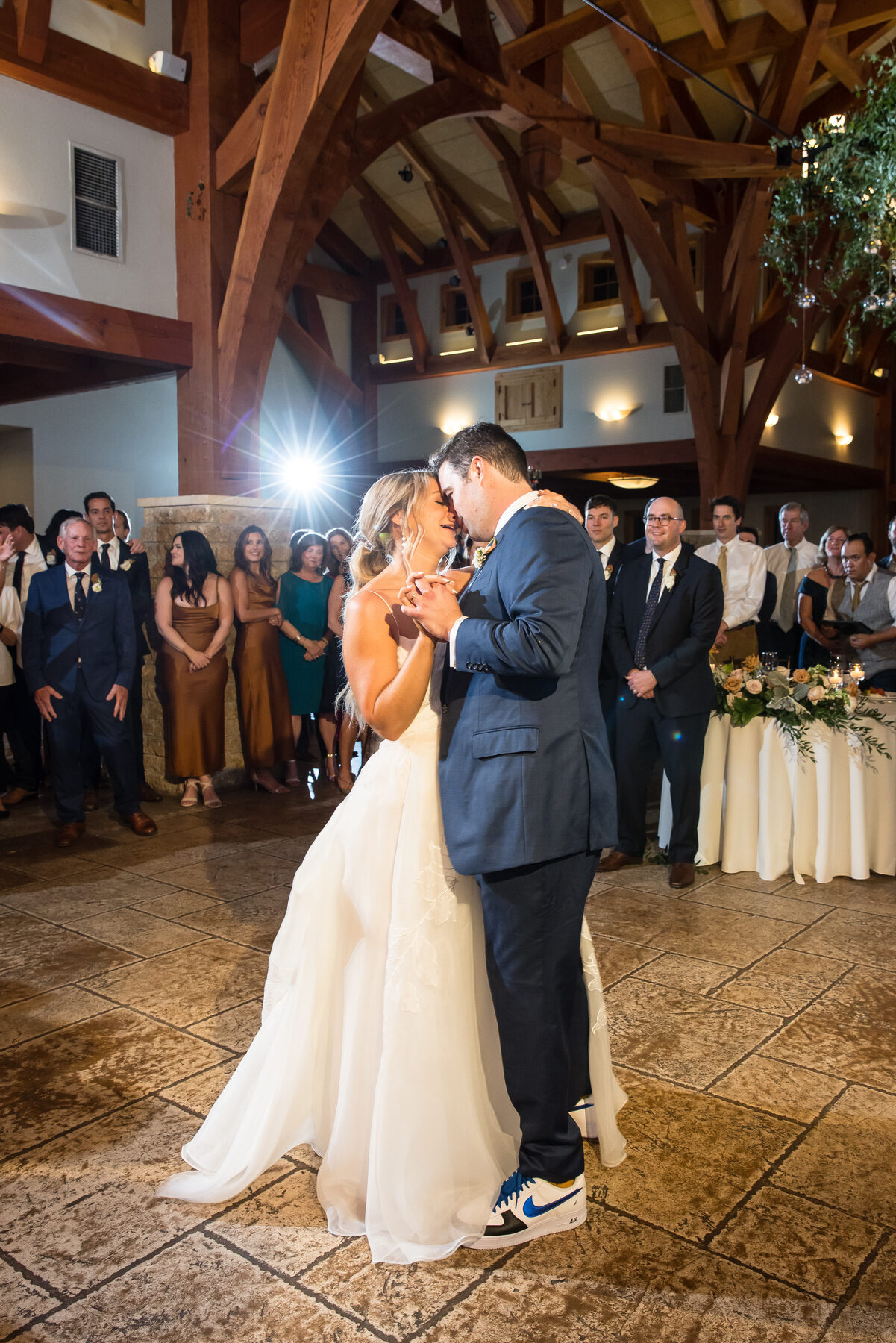 First dance with guests watching in a stone hall