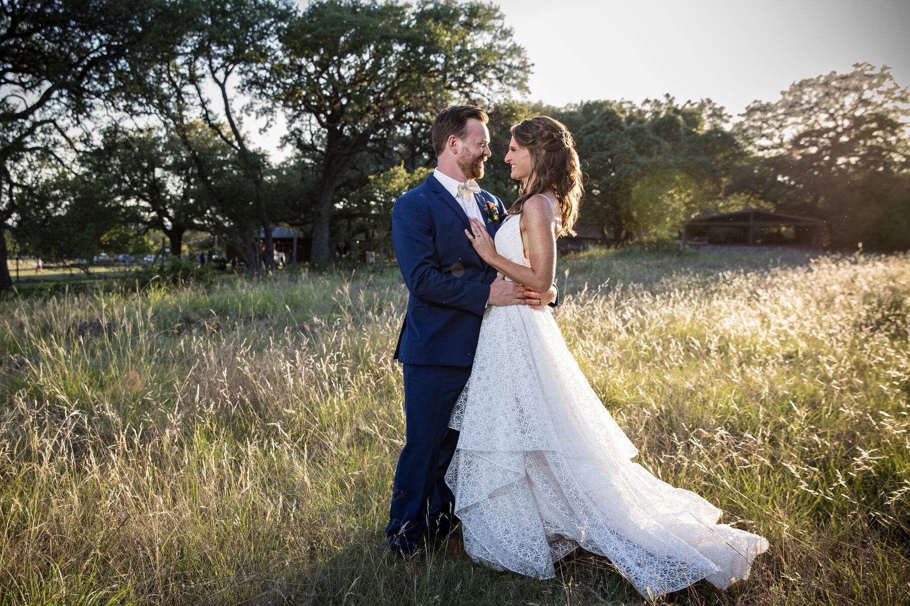 Couple in golden grass field at sunset