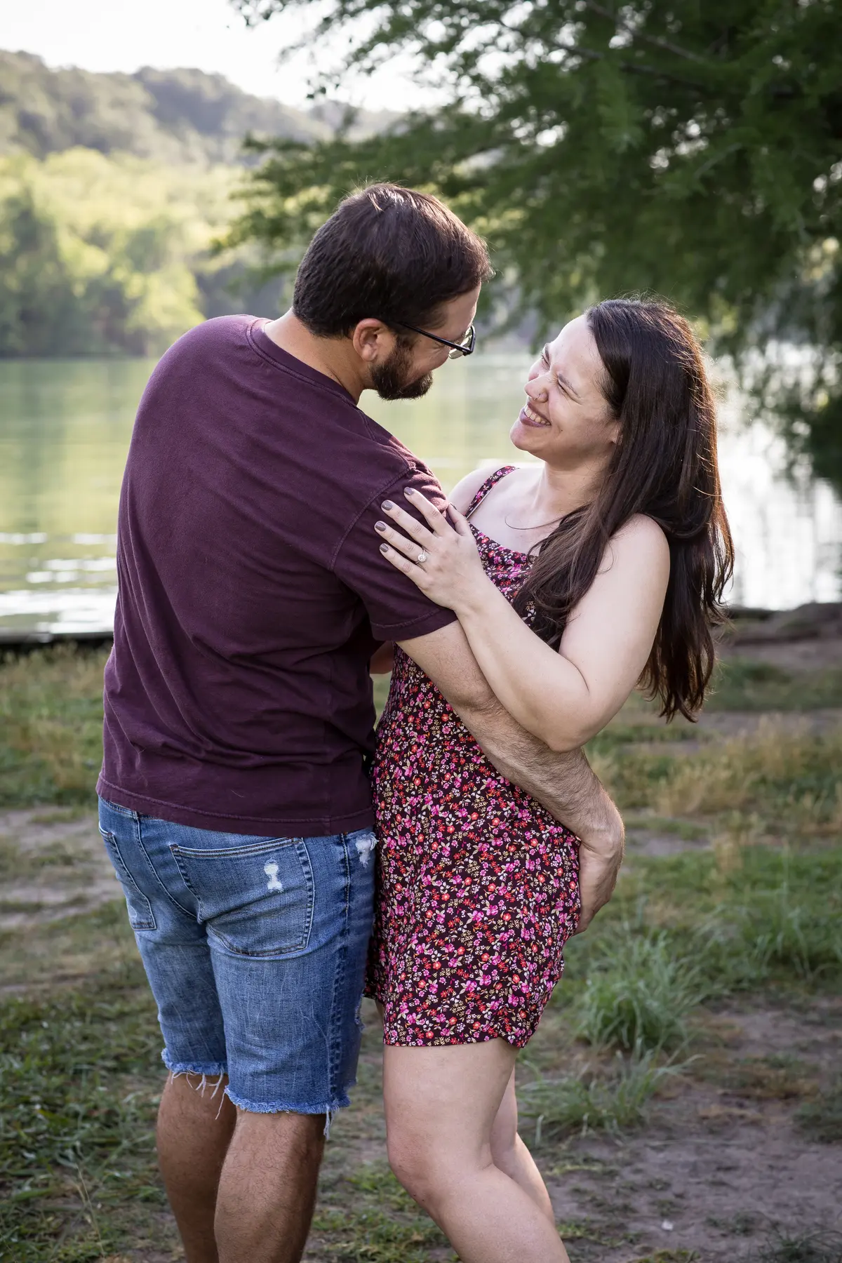 Engagement couple laughing by Austin river
