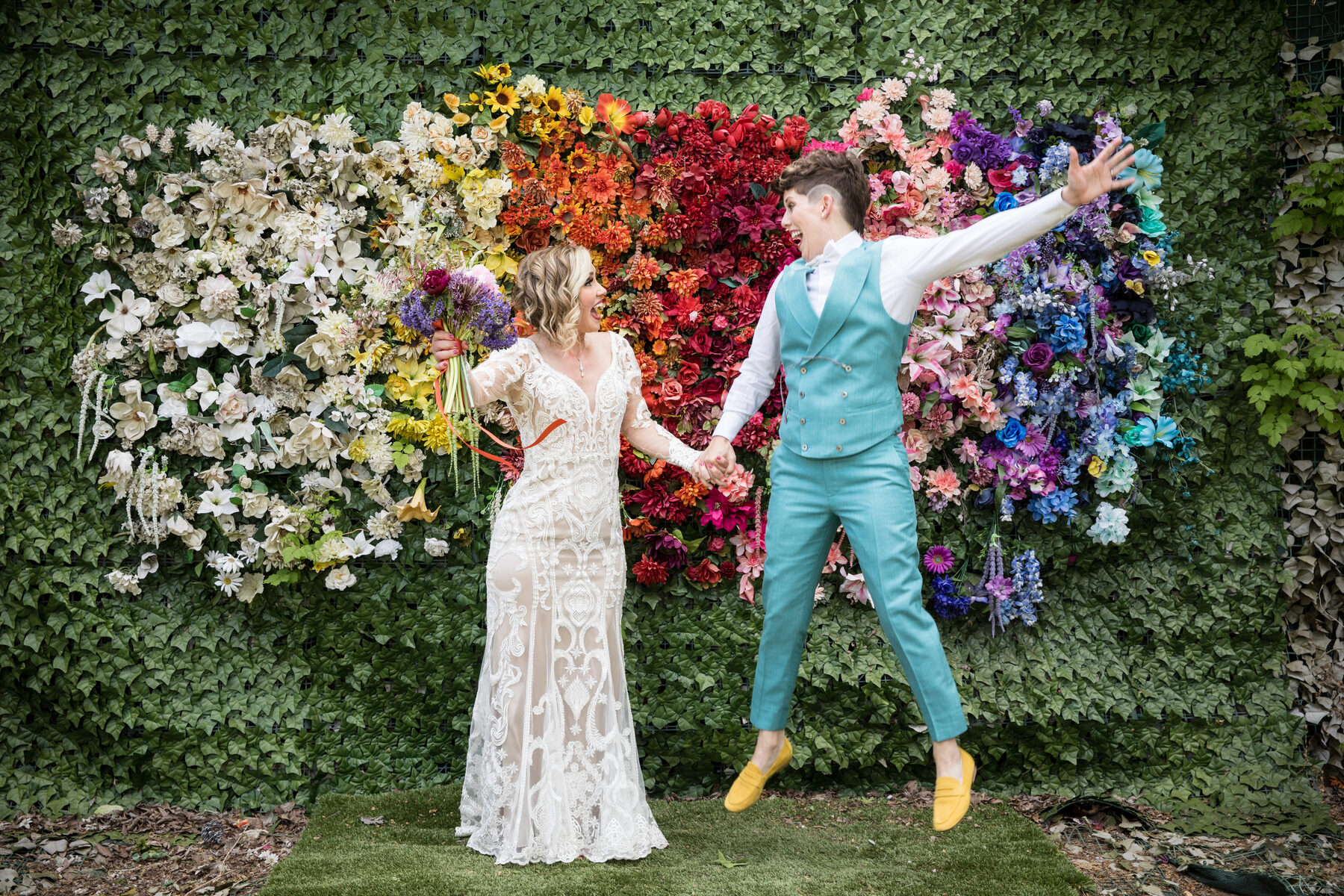 Couple in front of rainbow flower wall