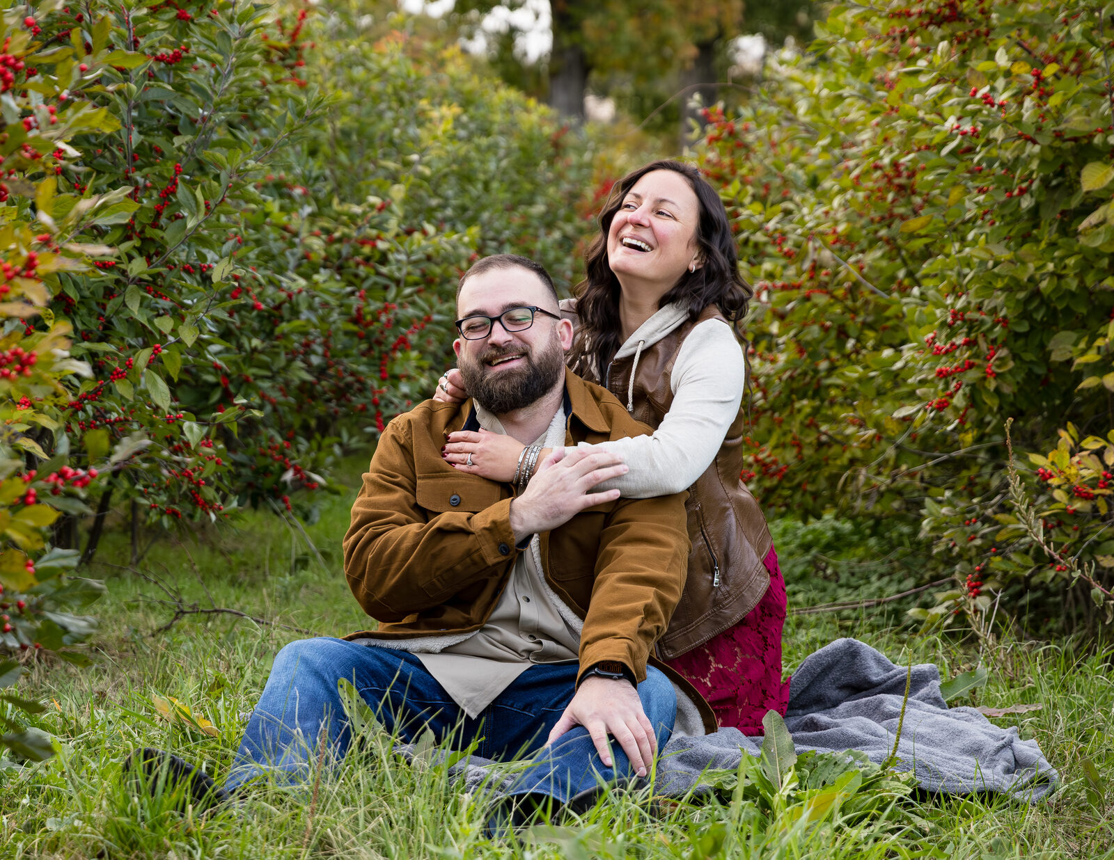 Couple laughing together in a grassy field