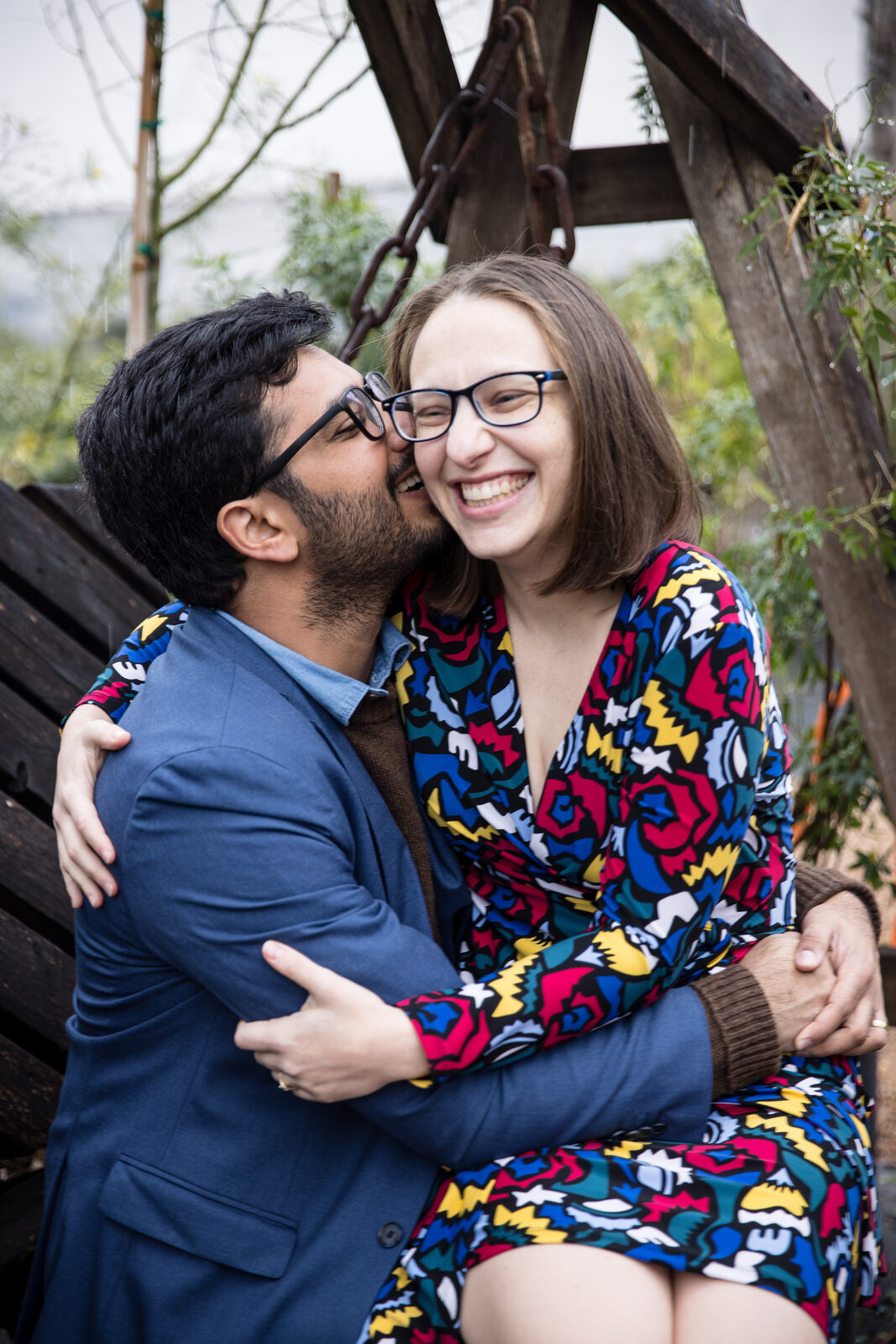 Couple laughing as he kisses her cheek