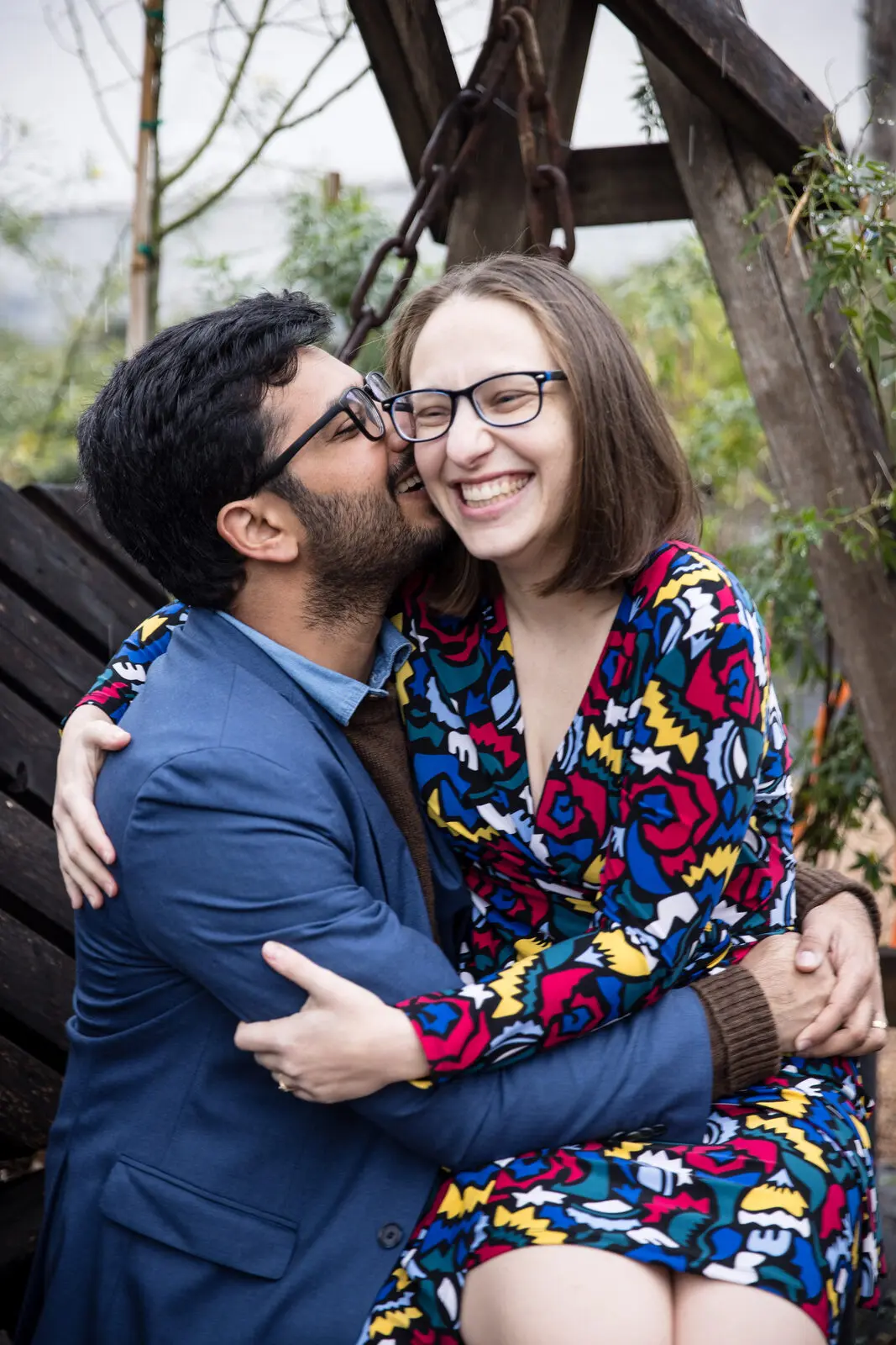 Couple laughing as he kisses her cheek