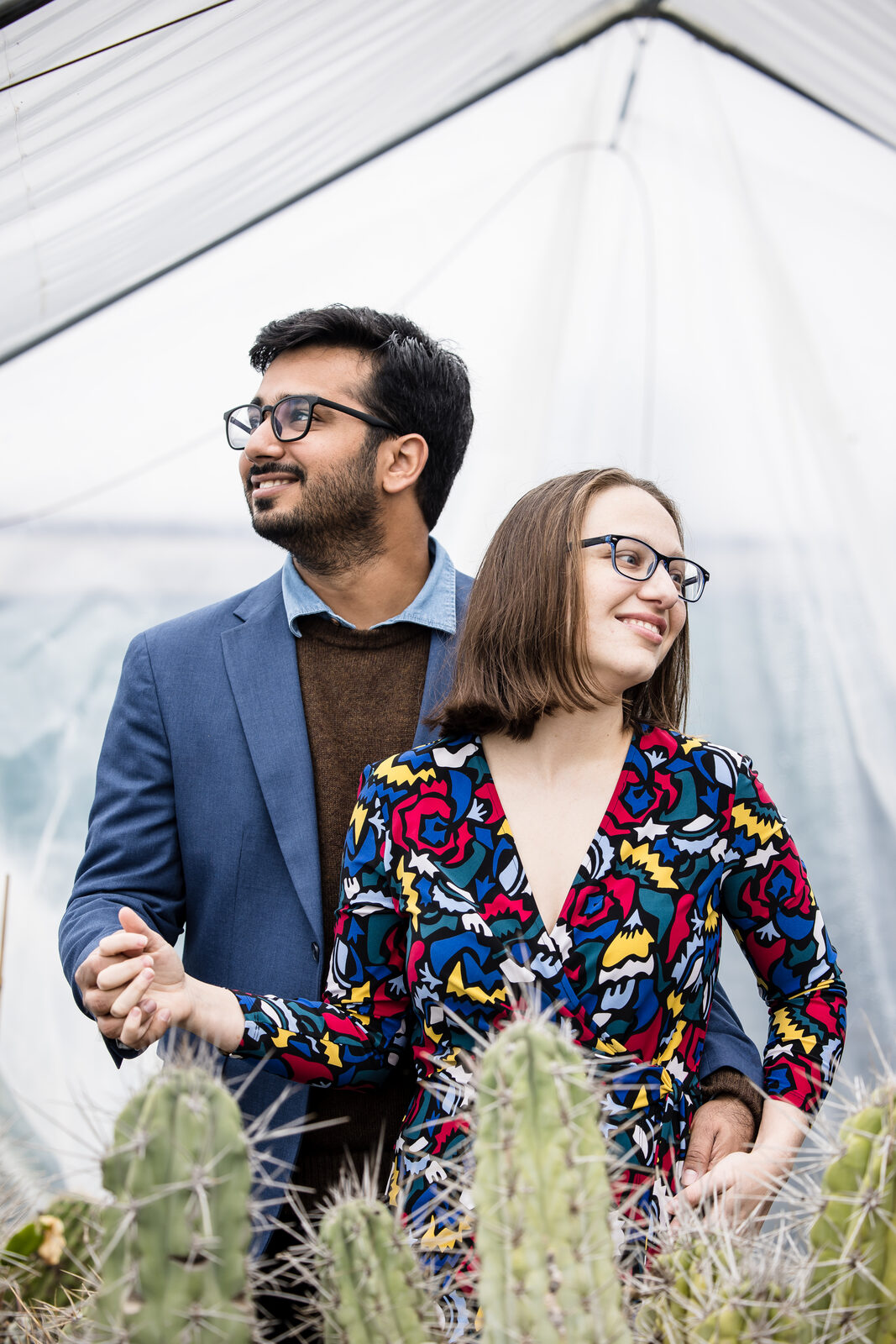 Couple holding hands in a sunlit greenhouse