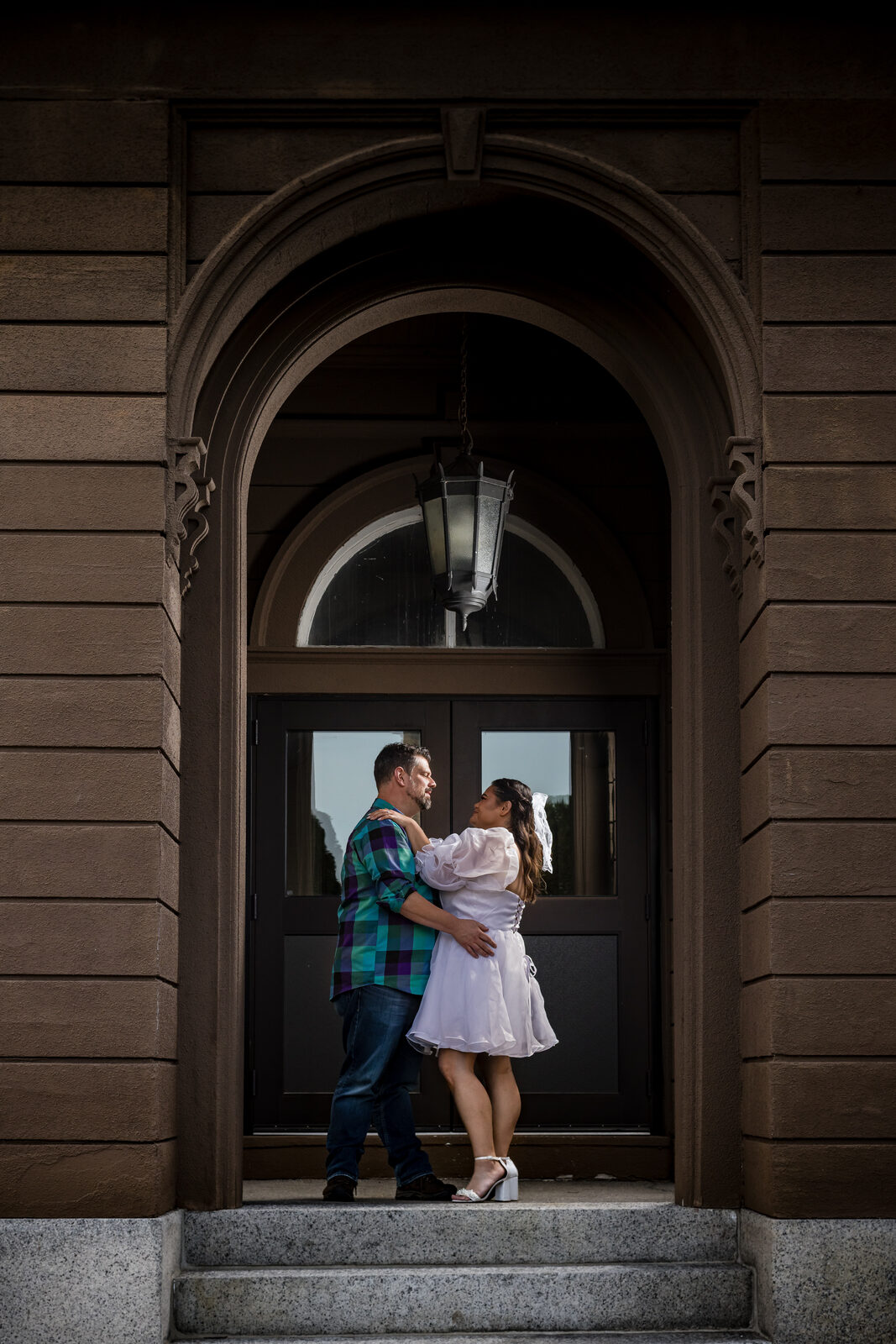 Couple embracing in a dramatic arched stone doorway