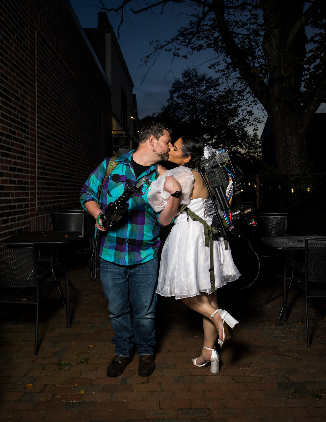 Couple kissing at night in Ghostbuster-themed engagement costumes