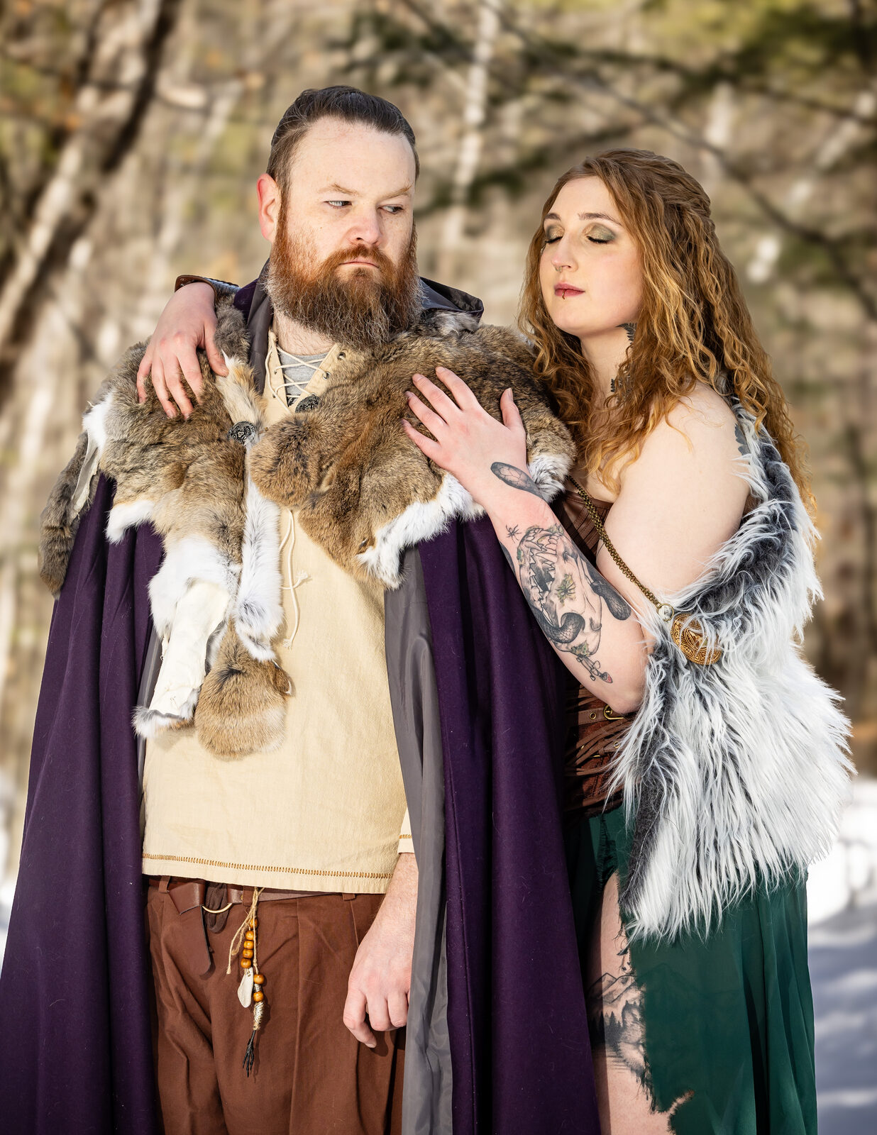 Viking-themed engagement portrait, couple embracing in the woods