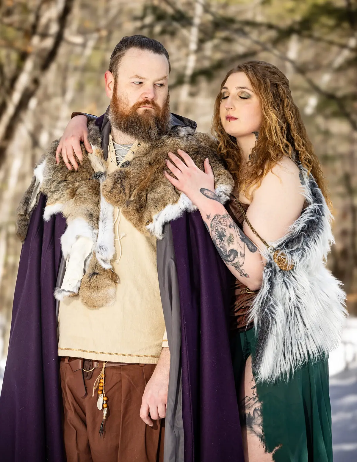 Viking-themed engagement portrait, couple embracing in the woods