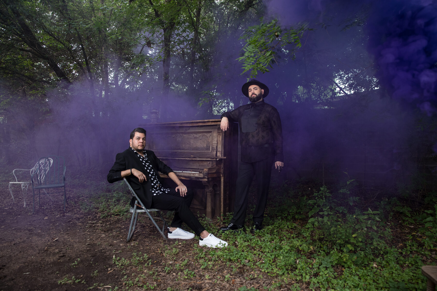 Two musicians by upright piano in purple smoke