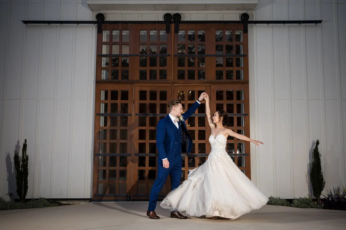 Couple dancing in front of large barn doors at night