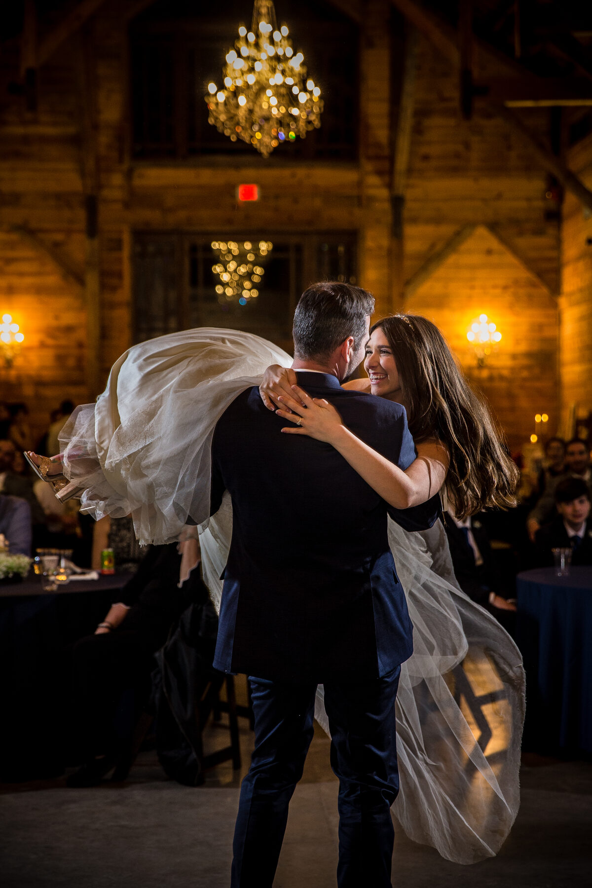 First dance with veil swirling under chandeliers